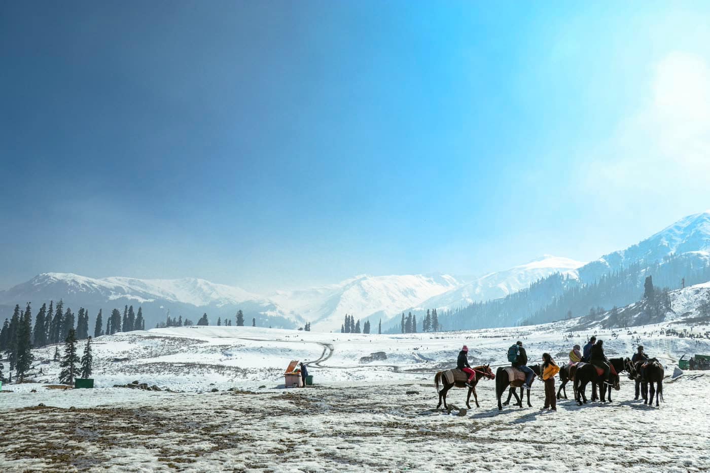 Horses and riders in deep snow at Gulmarg